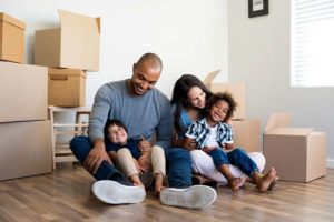 Family sitting, surrounded by moving boxes