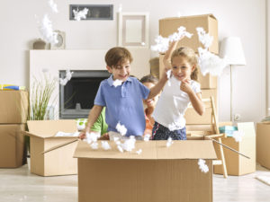 children inside a box playing with cotton fluff