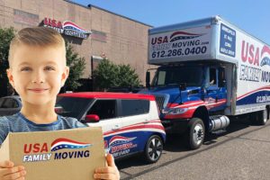 Boy smiling in front of USA Family Moving vehicles