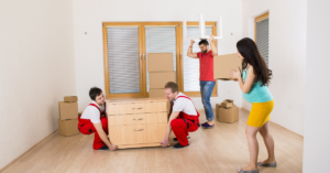 Pregnant woman and movers moving boxes